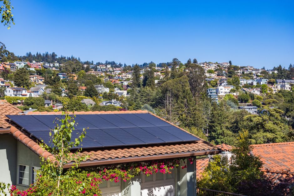 Rooftop solar panels on a UK house roof, compared with plug-in solar